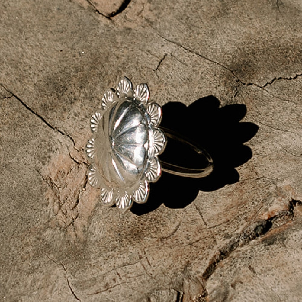 a Shop Marian Concho Queen Scarf Slide sitting on top of a piece of wood.