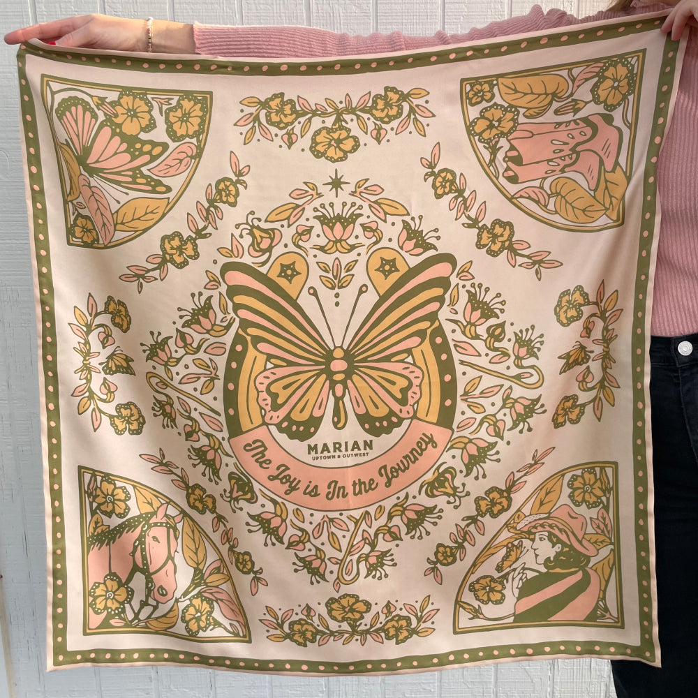 A woman showcases the strength and growth portrayed on a Shop Marian Butterfly Scarf.