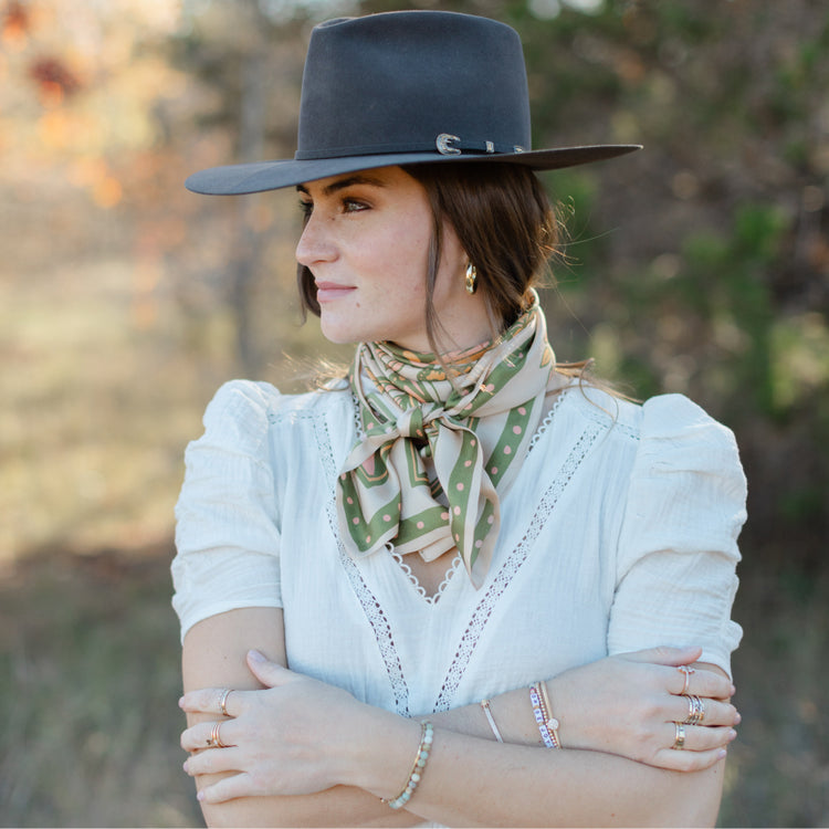 A woman wearing a cowboy hat and a Butterfly Scarf by Shop Marian, embracing growth in her journey as she struggles to find her inner butterfly.