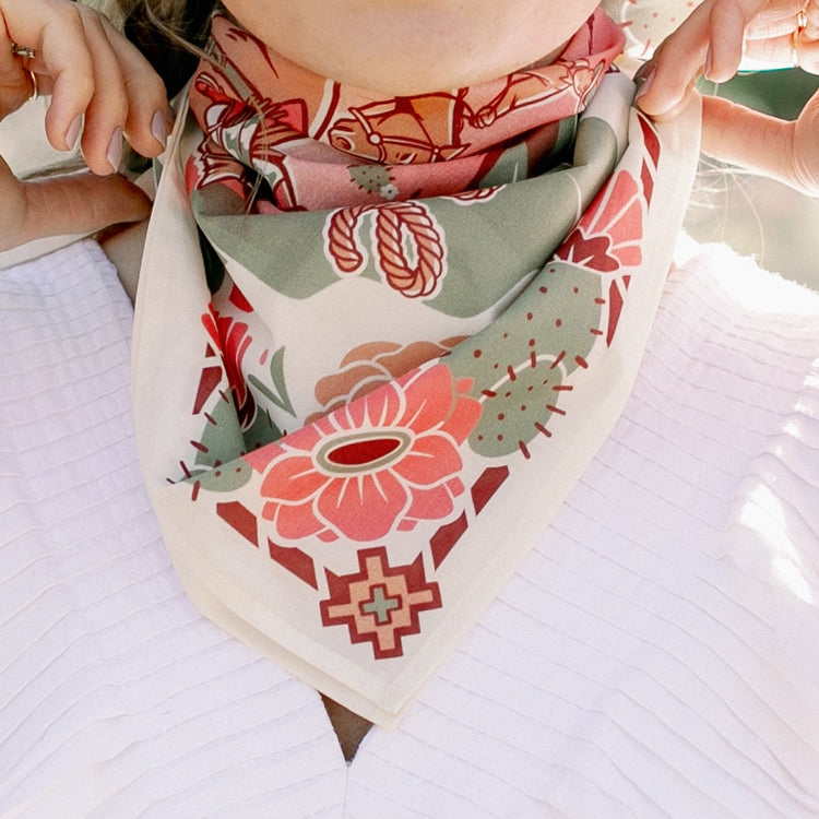 a woman wearing a Catch Me Scarf by Shop Marian with flowers on it.