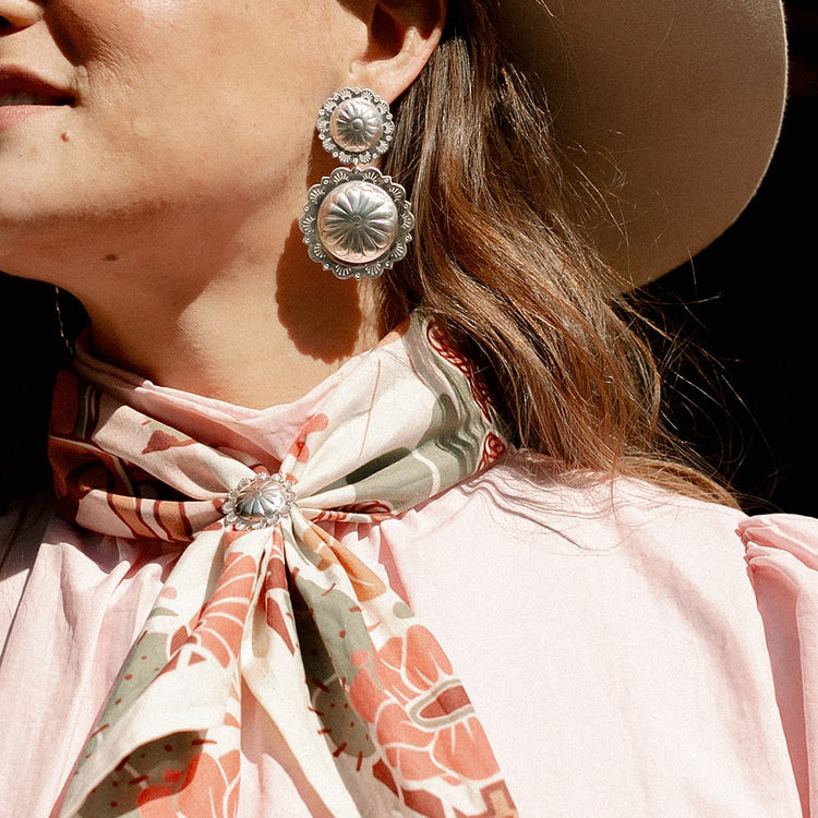 a woman wearing a Concho Queen Scarf Slide from Shop Marian.