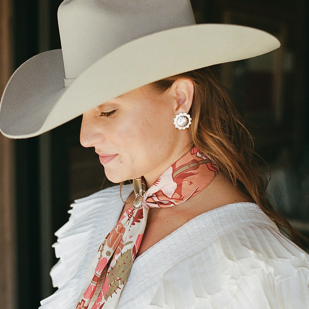 A woman wearing Shop Marian's Concho Queen Studs cowboy hat and scarf.