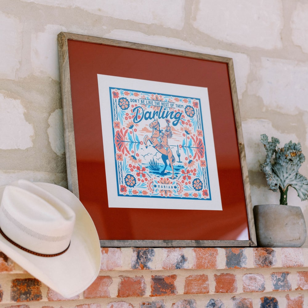 A Darling Print cowboy hat sits on top of a Shop Marian fireplace mantel.