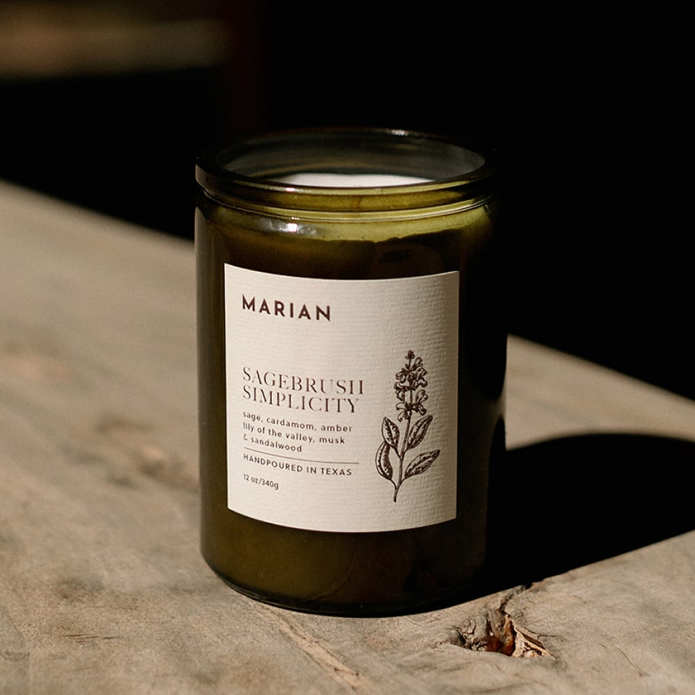 a jar of Sagebrush Simplicity candle sitting on a wooden table by Shop Marian.